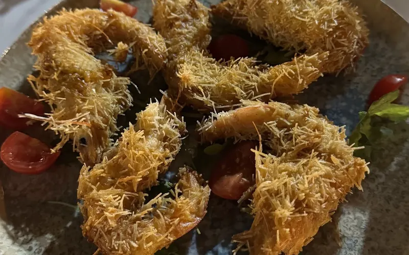 Shrimps wrapped in kadaif pastry on a dark plate