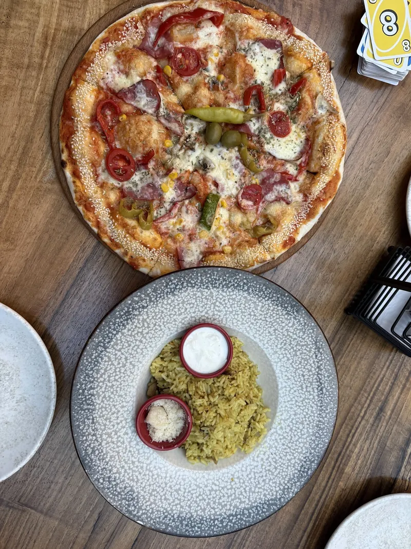 Pizza and a rice dish on a wooden table