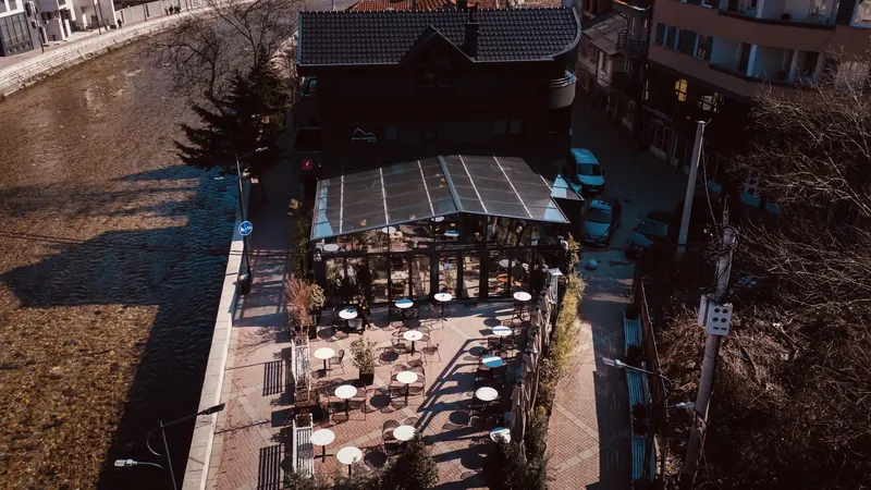 The lounge and its terrace on the riverside in Peja, seen from above